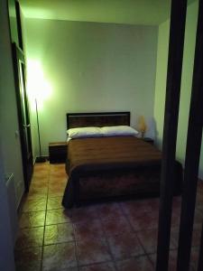 1 dormitorio con cama y pared verde en SIM residence, en Maniago