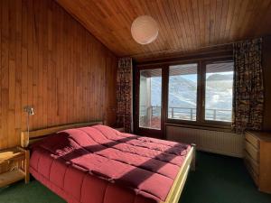 a bedroom with a large red bed and a window at 3 pièces au Val Claret avec parking et wifi, proche pistes - FR-1-449-169 in Tignes