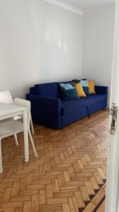 um sofá azul numa sala de estar com uma mesa em Greater Lisbon Cozy 2B Apartment - Odivelas em Odivelas