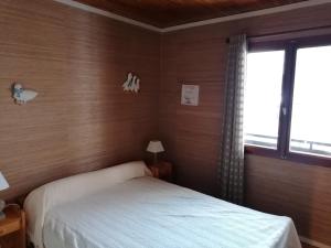 1 dormitorio con cama blanca y ventana en Chalet La Clusaz, 5 pièces, 6 personnes - FR-1-459-129 en La Clusaz