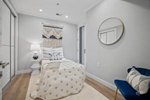 a white bedroom with a bed and a mirror at City Oasis By Meridian Park (Chapin 1) in Washington