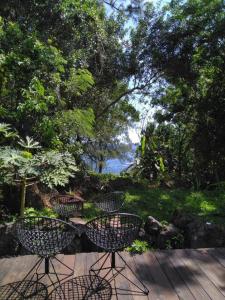 聖若瑟的住宿－La petite case jaune , jaccuzi pierre à 3 min à pied du bassin Manapany, vue mer，一组椅子坐在木甲板上