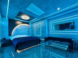 Dormitorio azul con cama y sofá en Hotel ZALA, en Kikuna