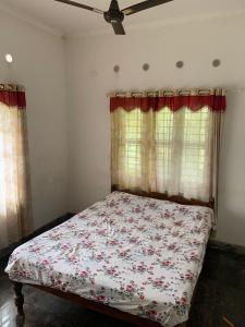 a bedroom with a bed with a floral comforter at Green valley Alleppey in Alleppey