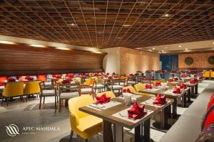 a dining room with tables and yellow chairs at Mia Apec Mandala Phú Yên in Tuy Hoa