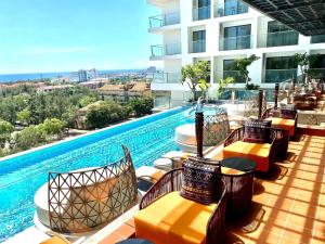 a hotel patio with chairs and a swimming pool at Mia Apec Mandala Phú Yên in Tuy Hoa