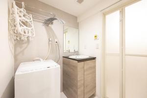 a white bathroom with a sink and a shower at Retaw Hills WASEDA in Tokyo