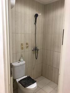 uma casa de banho com um chuveiro e um WC. em Troom Sentul City apartemen em Citaringgul 1