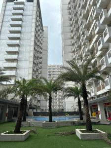 um grupo de palmeiras em frente a um edifício em Troom Sentul City apartemen em Citaringgul 1