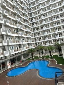 un gran edificio de apartamentos con una gran piscina en Troom Sentul City apartemen, en Citaringgul 1