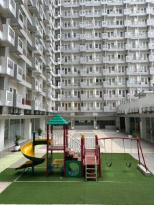 un parque infantil frente a un gran edificio de apartamentos en Troom Sentul City apartemen, en Citaringgul 1