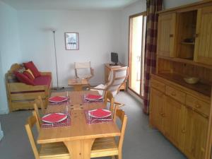 ヴァルフレジュスにあるAppartement Valfréjus, 3 pièces, 6 personnes - FR-1-265-182のダイニングルーム(赤い皿が並ぶテーブル付)