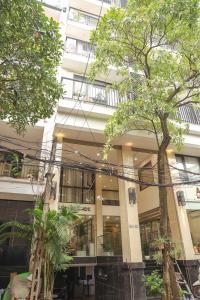 a building with trees in front of it at Wins Apartment in Hanoi