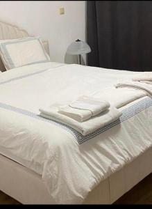 een wit bed met handdoeken erop bij Luxury apartment with sea view in Mezitli