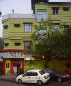 博帕爾的住宿－HOTEL THAKUR JI,Bhopal，停在大楼前的白色汽车
