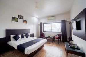a hotel room with a large bed and a desk at Saish Hotel Shirdi in Shirdi