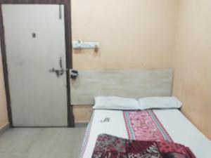 a bedroom with a bed with a door and a bedspread at HOTEL THAKUR JI,Bhopal in Bhopal
