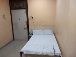 a small room with a bed and a door at HOTEL THAKUR JI,Bhopal in Bhopal