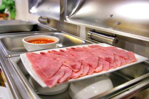 a tray of meat on a counter in a kitchen at Grand Elevation Hotel in Phnom Penh