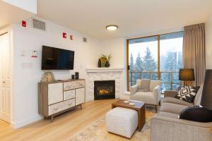 a living room with a fireplace and a tv at 600 SQFT 1 Bed 1 Bath Mountain View Suite at Cascade Lodge in Whistler Village Sleeps 4 in Whistler