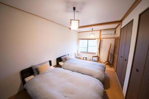 雾岛市おもや彩OmoyaSai-天然温泉付き貸別荘1棟貸し的一间带窗户的小房间里有两张床