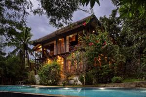 een huis met een zwembad ervoor bij The Red Hen Homestead in Batangas City