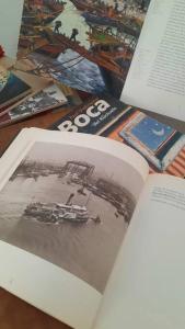 un libro aperto su un tavolo con una foto di una nave di Caminito B&B Un hospedaje único en La Boca con vista a Caminito a Buenos Aires