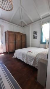 um quarto com uma cama branca e piso em madeira em Caminito B&B Un hospedaje único en La Boca con vista a Caminito em Buenos Aires