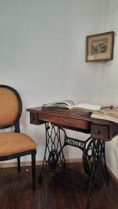 einen Schreibtisch mit einem Buch neben einem Stuhl in der Unterkunft Caminito B&B Un hospedaje único en La Boca con vista a Caminito in Buenos Aires