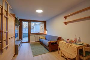 紹澤杜爾克西的住宿－Bianca's Studio 500mt From Ski - Happy Rentals，客厅配有蓝色的沙发和桌子
