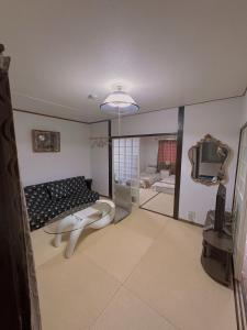 a living room with a couch and a tv at Nippori Osaka Nishi-Tengachaya Guesthouse西天下茶屋アパートメント in Osaka