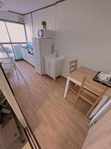 a small kitchen with a table and a refrigerator at Nippori Osaka Nishi-Tengachaya Guesthouse西天下茶屋アパートメント in Osaka