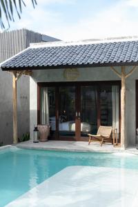 a resort with a swimming pool and a bed at Kano Twin in Canggu