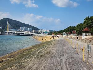 a beach with people on it next to the water at Ungcheon Hotel Travel Bag in Yeosu
