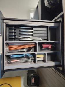 a drawer full of utensils in a cabinet at Ungcheon Hotel Travel Bag in Yeosu