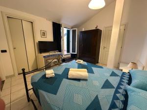 una camera da letto con un letto blu con due asciugamani di La Spezia Vezzano 5 terre - Il Ciliegio a Vezzano Ligure