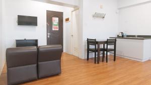 a living room with a table and chairs and a kitchen at RedDoorz at BP International near SM Manila in Manila