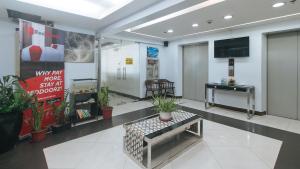 a lobby with a waiting area with plants and a tv at RedDoorz at BP International near SM Manila in Manila