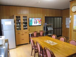 Sala de conferencias con mesa, sillas y TV en ゲストハウス あずも GuestHouse AZMO, en Matsue