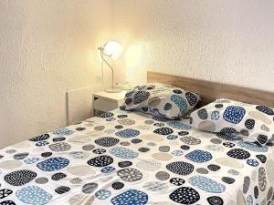 Cama con sábanas y almohadas azules y blancas en Studio Balaruc-les-Bains, 1 pièce, 4 personnes - FR-1-503-25, en Balaruc-les-Bains