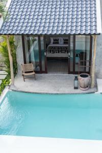a house with a gazebo next to a swimming pool at Kano Twin in Canggu