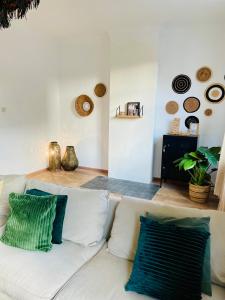 uma sala de estar com um sofá branco com duas almofadas em Woning op 5 min wandelafstand van de Schorre en van het festival Tomorrowland ! em Boom