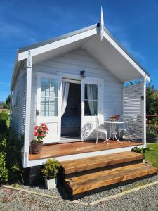 a tiny house with a porch and a deck at Petite on Regent in Martinborough 