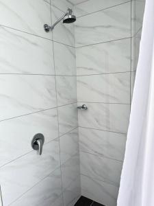 a shower stall with a glass door with a shower at Twin City Motor Inn in Wodonga
