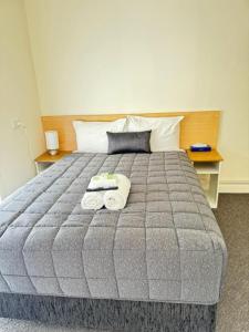 a bedroom with a bed with two towels on it at Twin City Motor Inn in Wodonga