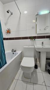 een witte badkamer met een toilet en een wastafel bij Bros Inn Hotel in Londen