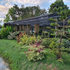 ein altes Haus mit Blumen davor in der Unterkunft Baandin resort in Sukhothai