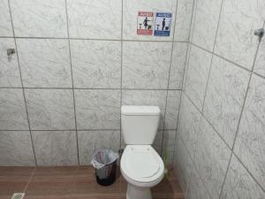 a bathroom with a toilet in a tiled wall at B & B Hostels Balneário in Balneário Camboriú