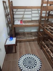 Habitación con litera, silla y alfombra. en B & B Hostels Balneário en Balneario Camboriú