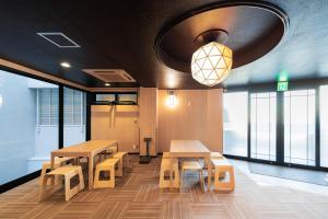 東京にあるE JOY INN-East Nipoori Branchのテーブルとベンチと窓のある部屋